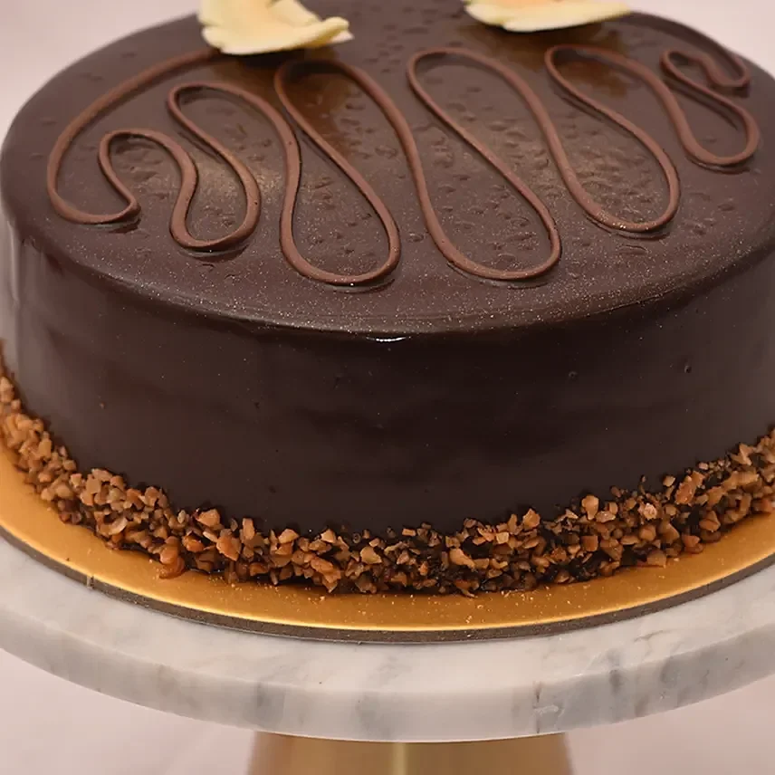Bánh kem socola tròn trang trí bằng sốt chocolate và hạt vụn