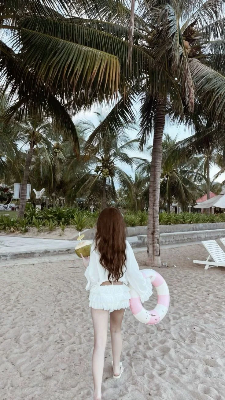 Gái xinh che mặt cầm phao bơi đi dạo trên bãi biển
