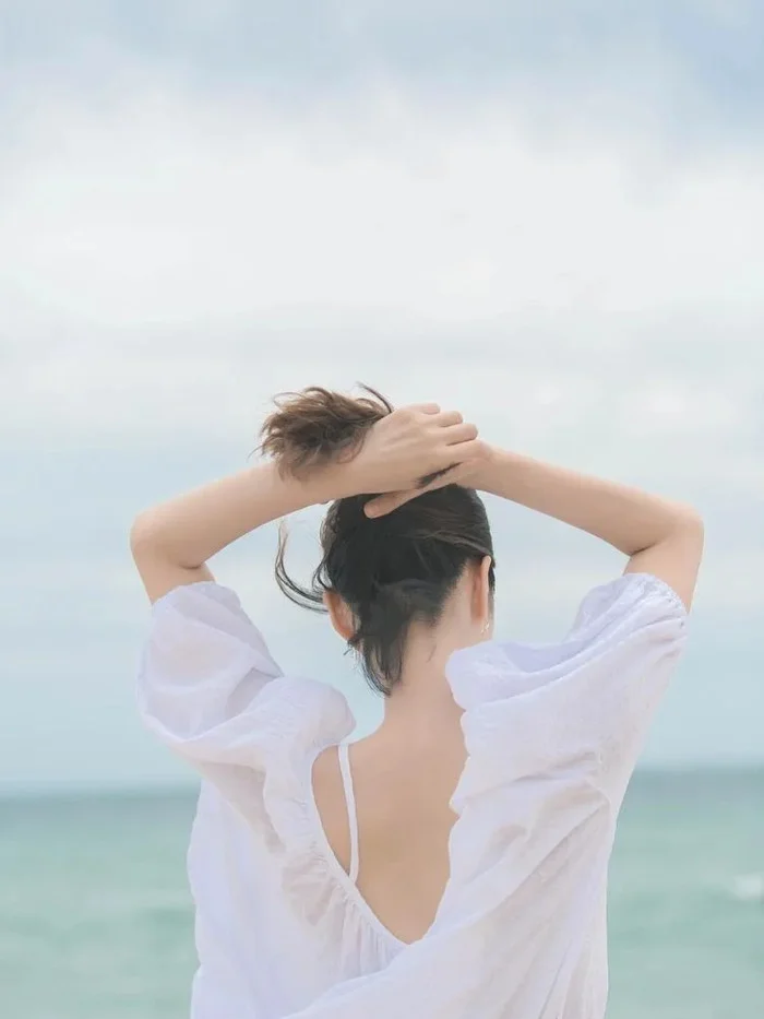 Gái xinh che mặt buộc tóc trên bãi biển