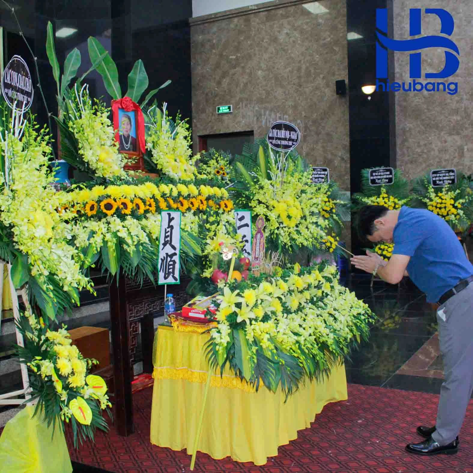 Người đàn ông cúi đầu cầu nguyện trước bàn thờ trong ảnh đám tang trang nghiêm