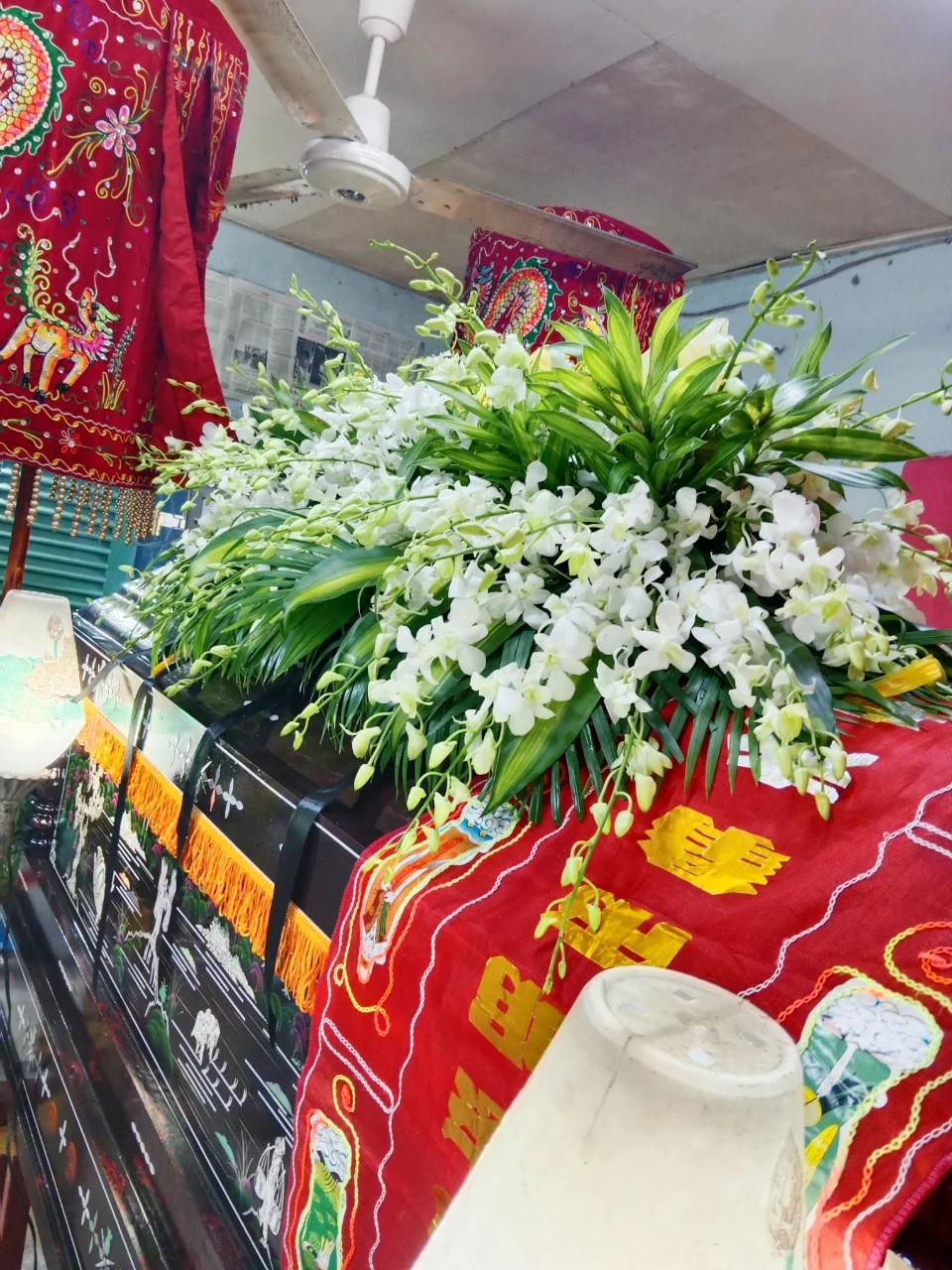 ảnh đám tang với quan tài được phủ hoa lan trắng trang trọng