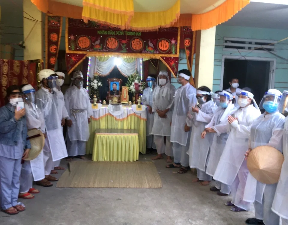 Người thân mặc đồ bảo hộ trong ảnh đám tang truyền thống tại Việt Nam